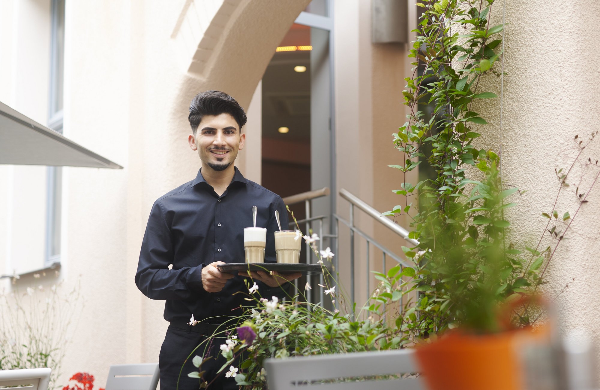 Hotelmitarbeiter bringt Kaffee auf die Terrasse